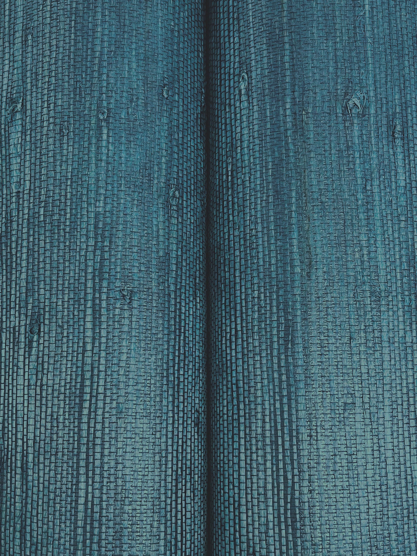 Teal blue ribbed fabric close-up with vertical wales and a central seam.