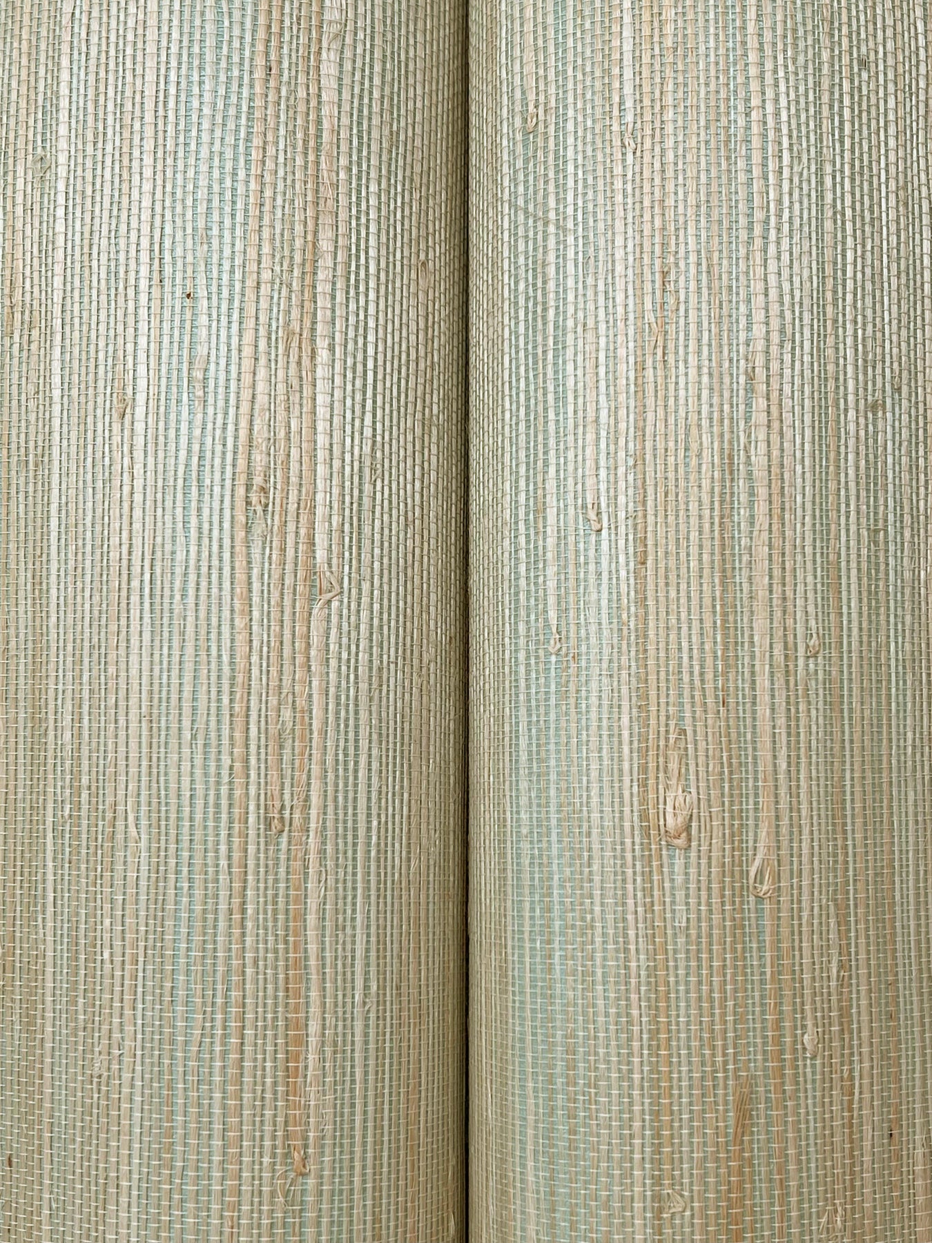 Close-up of pale vertical wooden planks with a subtle green tint, showing grain and knots for wall paneling.