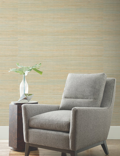 Gray fabric armchair with boxy arms and tapered wooden legs beside a small side table and vase in a modern living room.