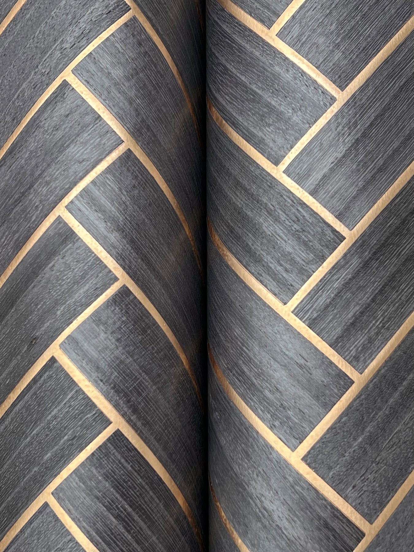 Close-up of charcoal gray graphite herringbone wood-veneer wallpaper.