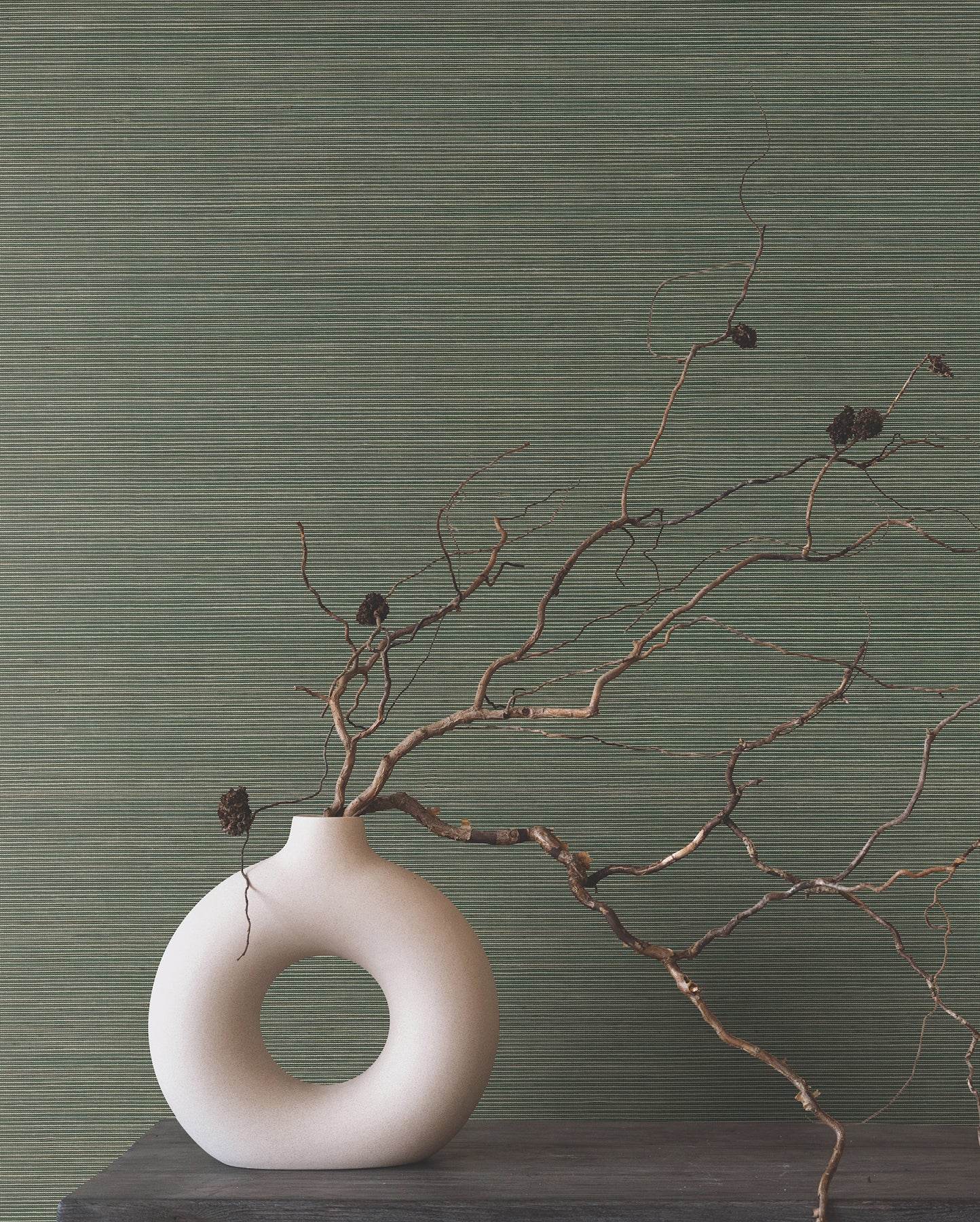 Green forest grasscloth wallpaper with natural textured finish on the wall.