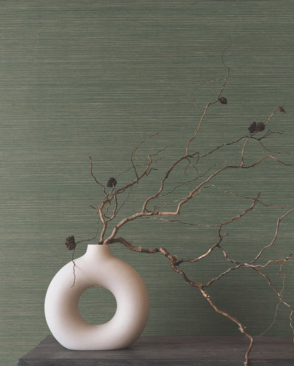 Green forest grasscloth wallpaper with natural textured finish on the wall.