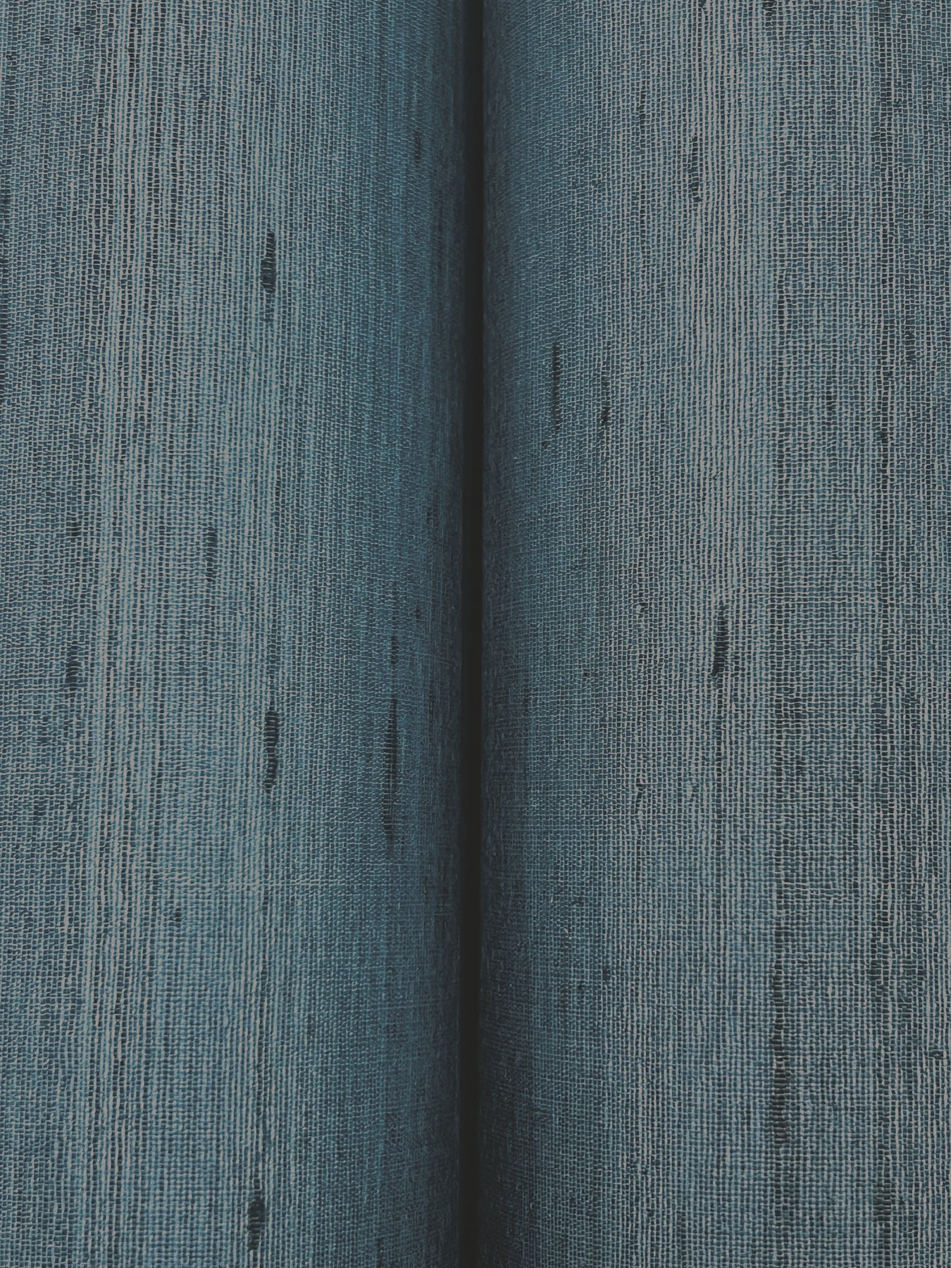 Close-up of navy wallpaper with a subtle textured weave and dark flecks.