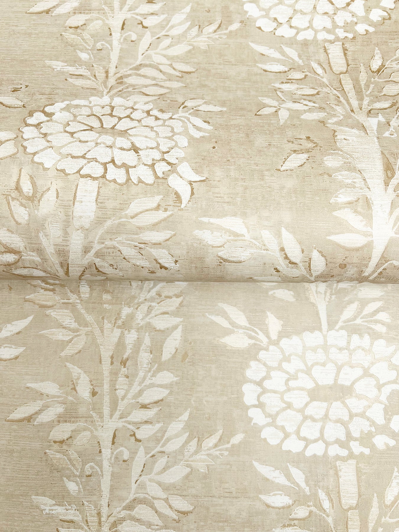 Beige-taupe wallpaper with a gold and brown floral pattern and leafy stems.