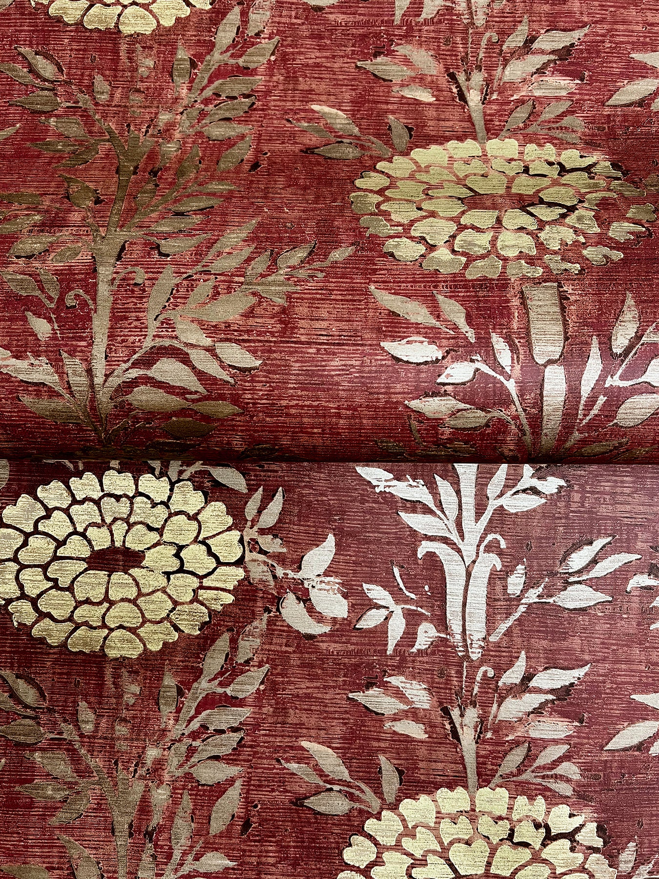 Close-up of burgundy wallpaper with large cream floral motifs and pale gray foliage.