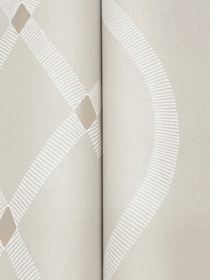 Grey wallpaper detail with geometric diamond motif and a white dashed curved stripe; two-panel seam