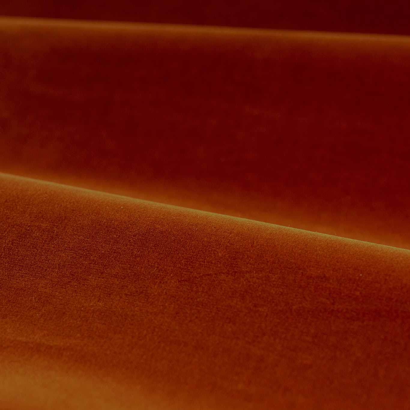 Close-up of luxurious Zoffany cotton velvet performance fabric in a warm terracotta shade. The soft matte finish and rich texture highlight its high-quality cotton-polyester blend, ideal for upholstery, curtains, and soft furnishings. Elegant drape with subtle sheen and durable, stain-resistant surface.
