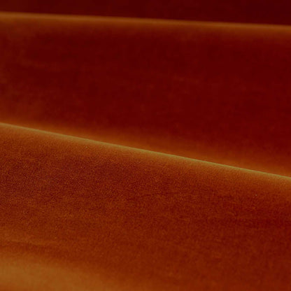 Close-up of luxurious Zoffany cotton velvet performance fabric in a warm terracotta shade. The soft matte finish and rich texture highlight its high-quality cotton-polyester blend, ideal for upholstery, curtains, and soft furnishings. Elegant drape with subtle sheen and durable, stain-resistant surface.