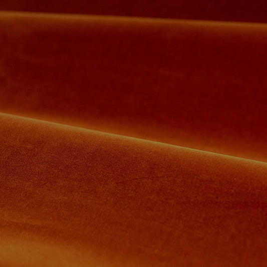 Close-up of luxurious Zoffany cotton velvet performance fabric in a warm terracotta shade. The soft matte finish and rich texture highlight its high-quality cotton-polyester blend, ideal for upholstery, curtains, and soft furnishings. Elegant drape with subtle sheen and durable, stain-resistant surface.