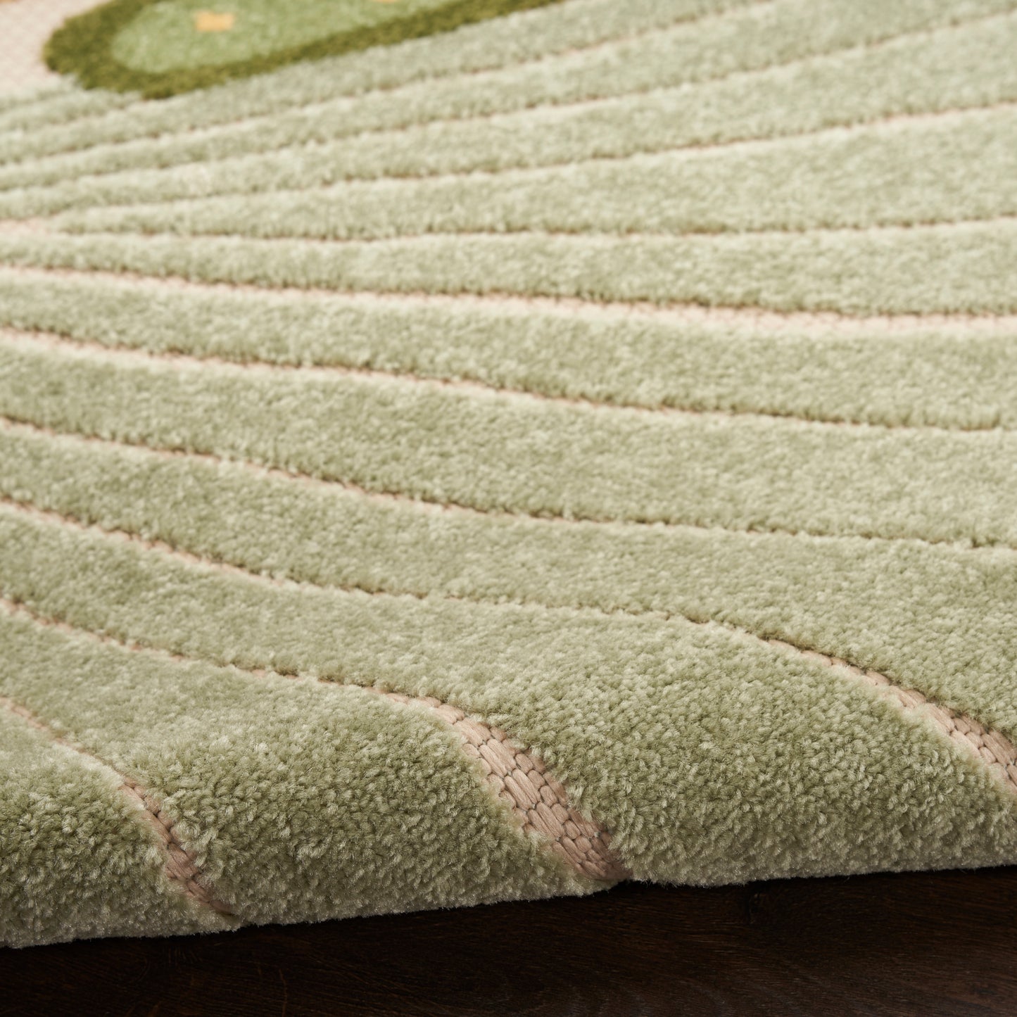 Olive green outdoor rug with cream curved lines and ribbed texture on dark wood floor.