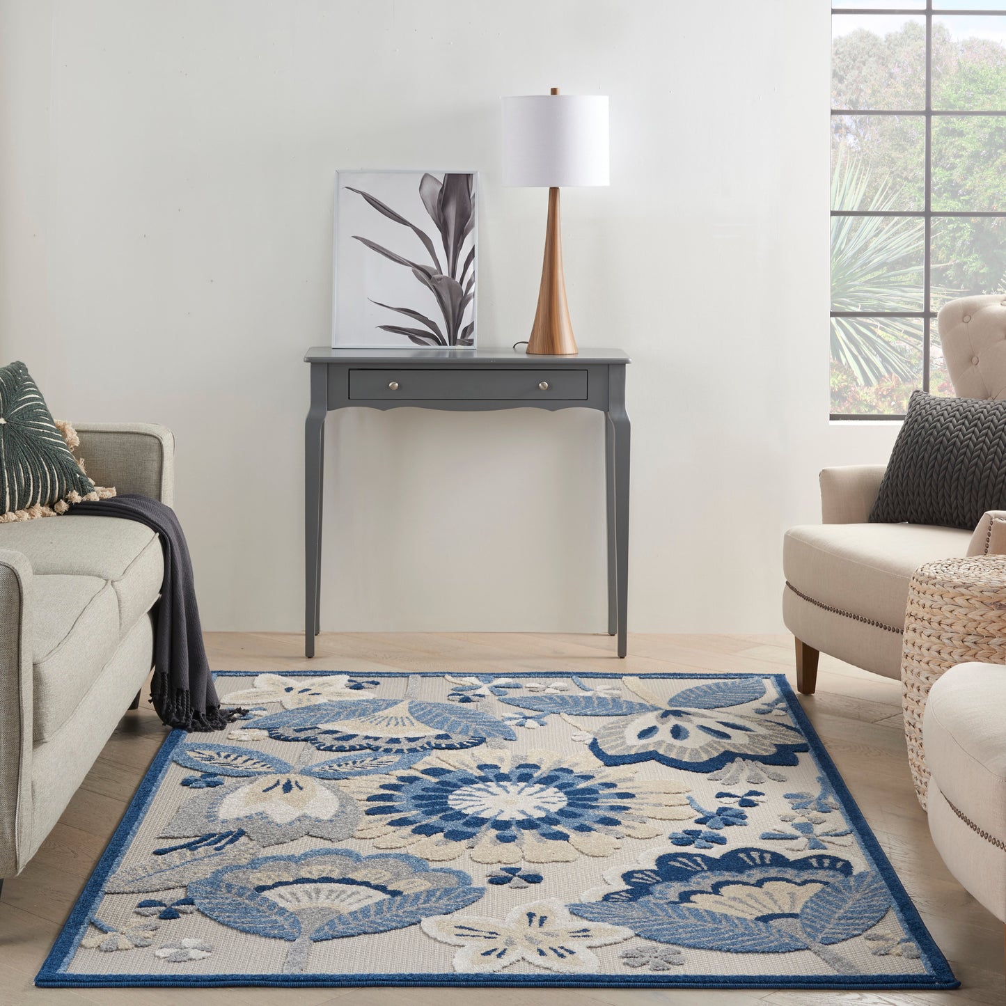 Blue floral area rug with cream background and blue border; woven texture, modern living room decor.