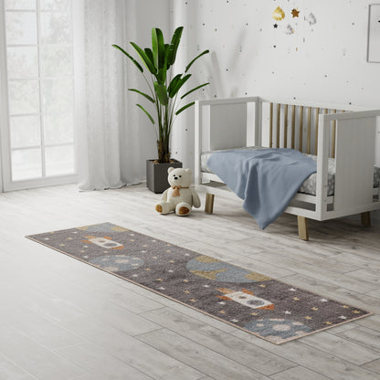 Long gray kid's runner rug with orange and white shapes in a bright nursery beside a white crib, plush bear, and tall plant.