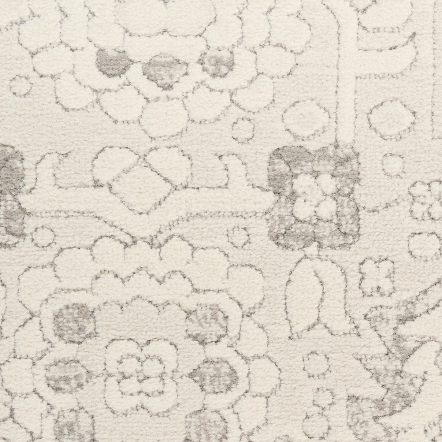 Beige high-pile rug with soft gray floral and geometric motifs.
