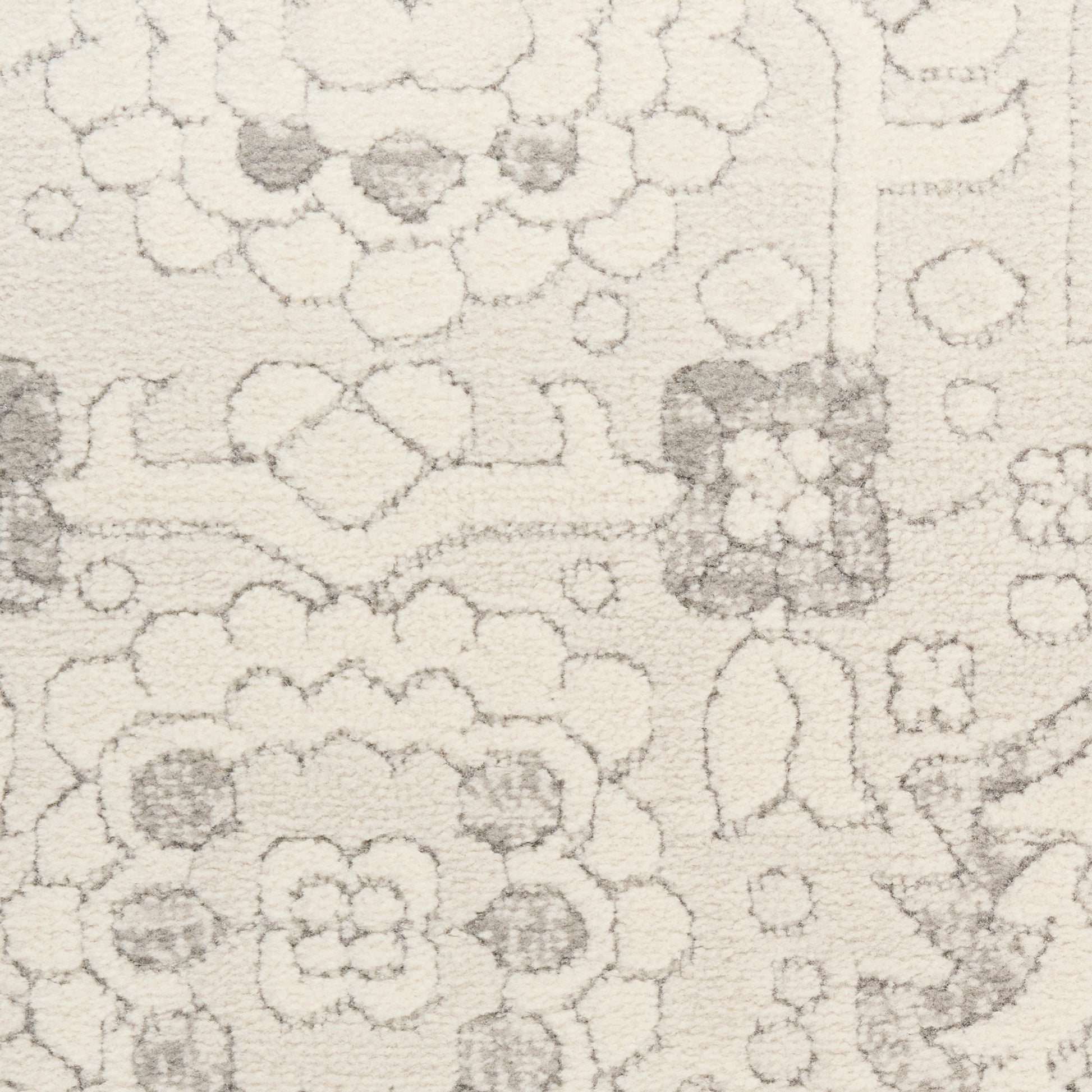 Beige high-pile rug with soft gray floral and geometric motifs.
