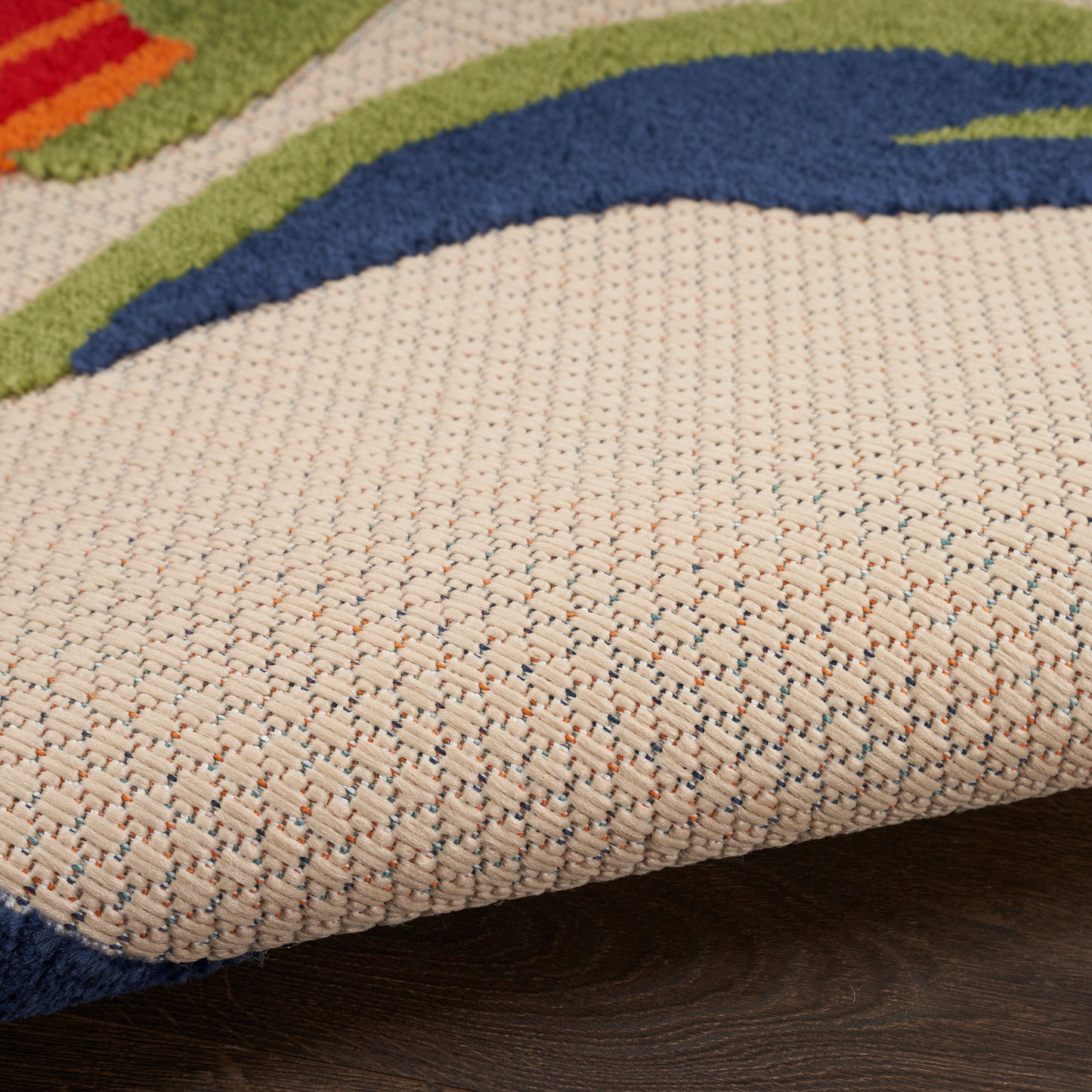 Beige flat-weave rug with speckled yarns and bold blue, green and orange abstract curves; woven texture.
