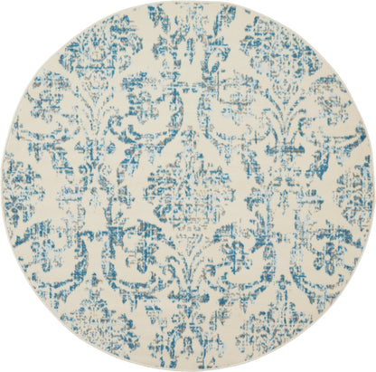 Round decorative rug with cream base and blue distressed damask pattern.