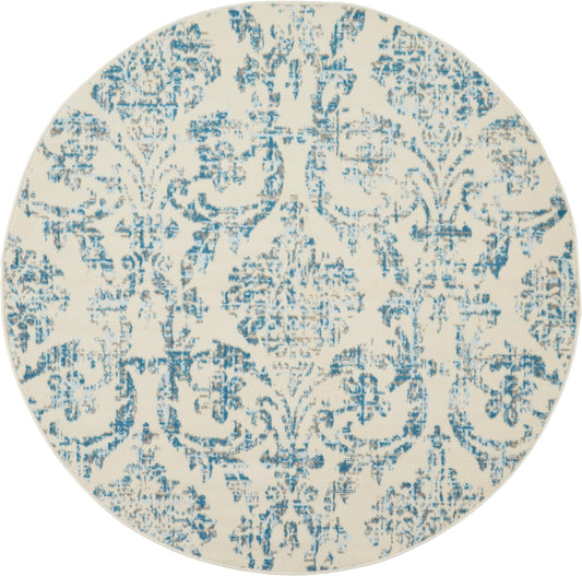 Round decorative rug with cream base and blue distressed damask pattern.