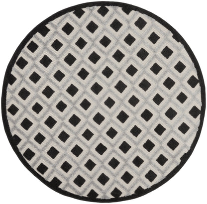 Round gray rug with white lattice and black diamond accents, black border; soft rug.