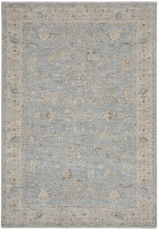 Light blue traditional area rug with ivory floral motifs and a pale beige border.