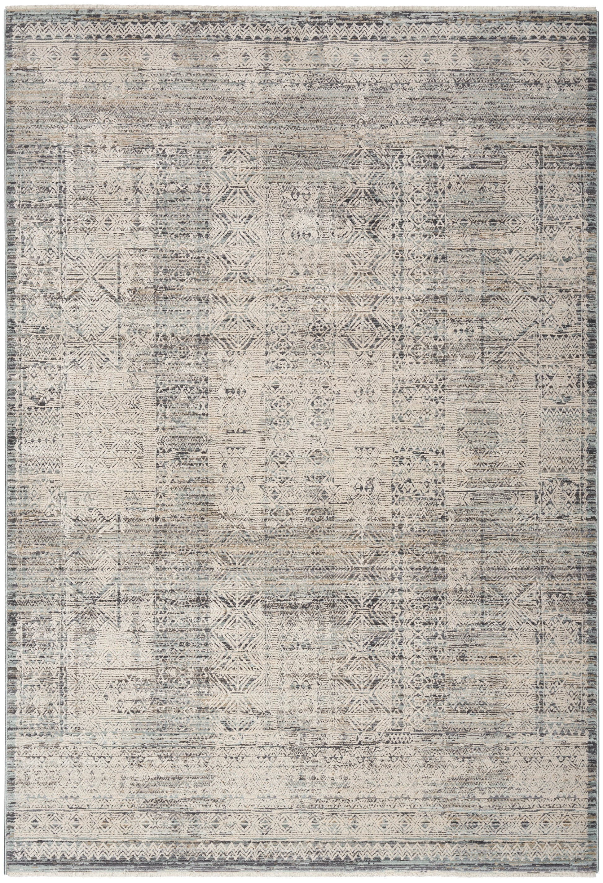 Distressed vintage patchwork rug with geometric motifs in muted beige, gray & blue, framed by subtle borders.
