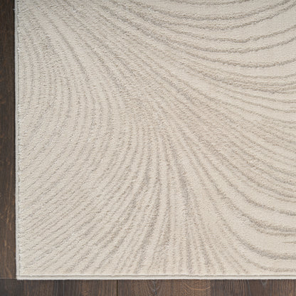 Beige textured area rug with subtle swirled wave pattern on dark wood floor