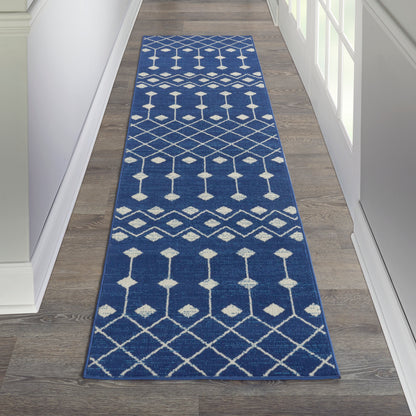 Blue woven runner rug with white geometric diamonds and lattice pattern in a hallway.