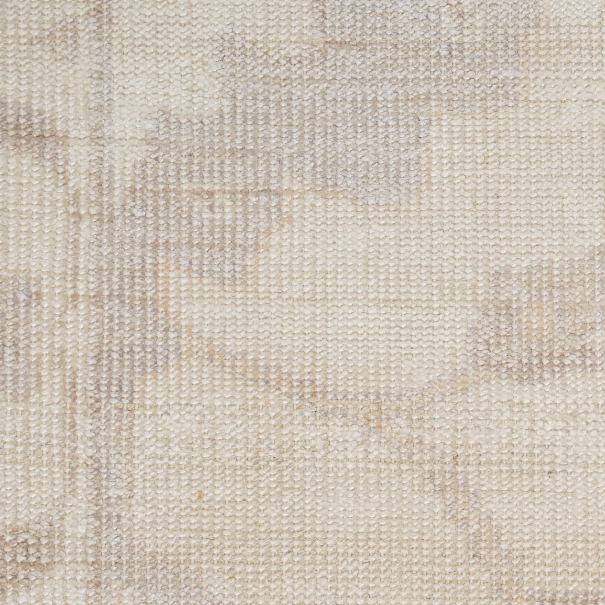 Beige woven rug close-up with subtle cream and taupe circular pattern, textured fabric.