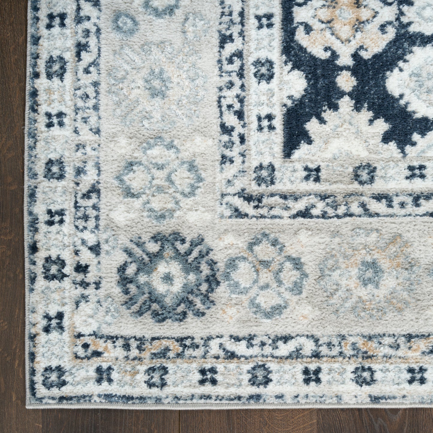 Ivory and navy oriental area rug with blue floral medallions and a bordered pattern; rectangular living room rug.