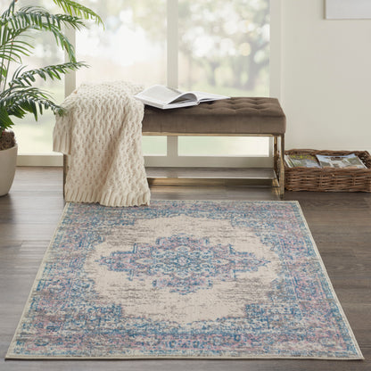 Rectangular vintage-style rug with cream base and faded blue and pink motifs, beside a tufted brown bench and knit throw.