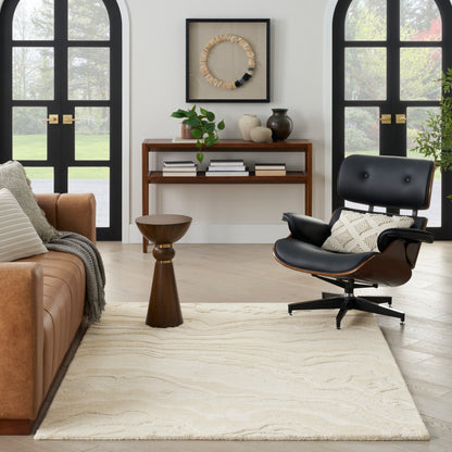 Mid-century living room with brown leather sofa, black Eames lounge chair, cream rug, plant, and arched windows.
