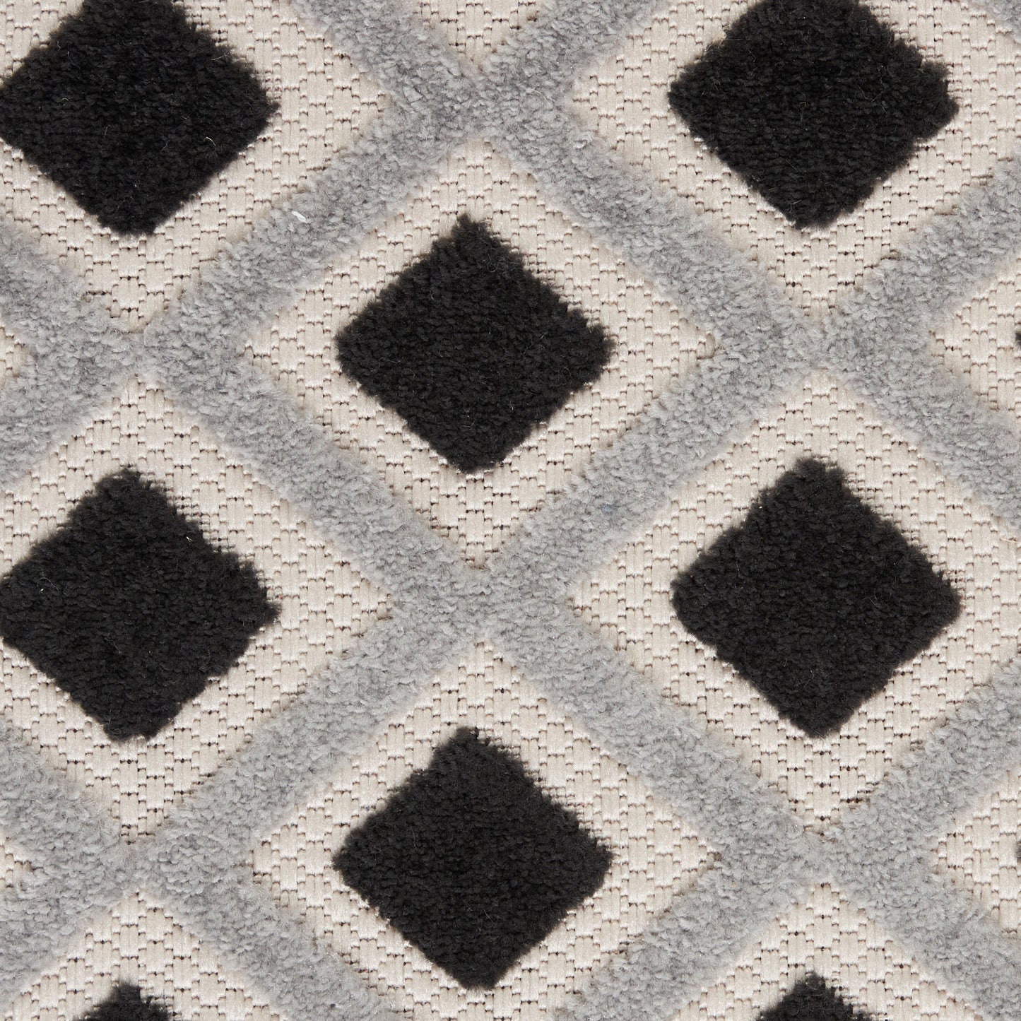 Textured rug with black diamond centers within light gray diamond lattice on a cream background.