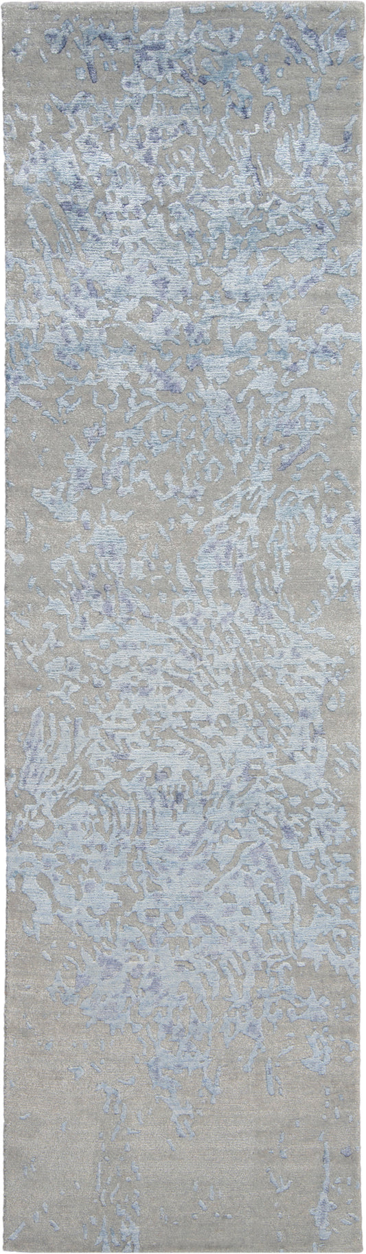 Beige abstract area rug with pale blue and lavender irregular motif; modern textured design.