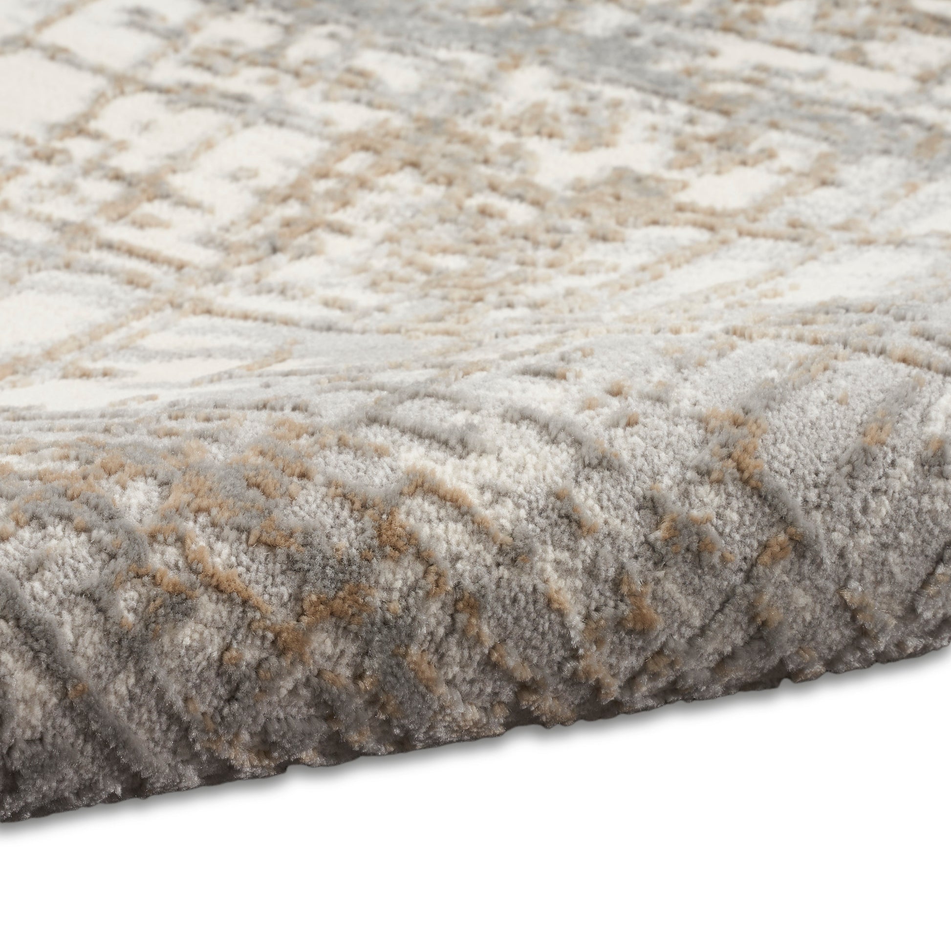 Soft plush area rug in beige, gray & taupe with a textured geometric pattern & thick, fluffy pile.