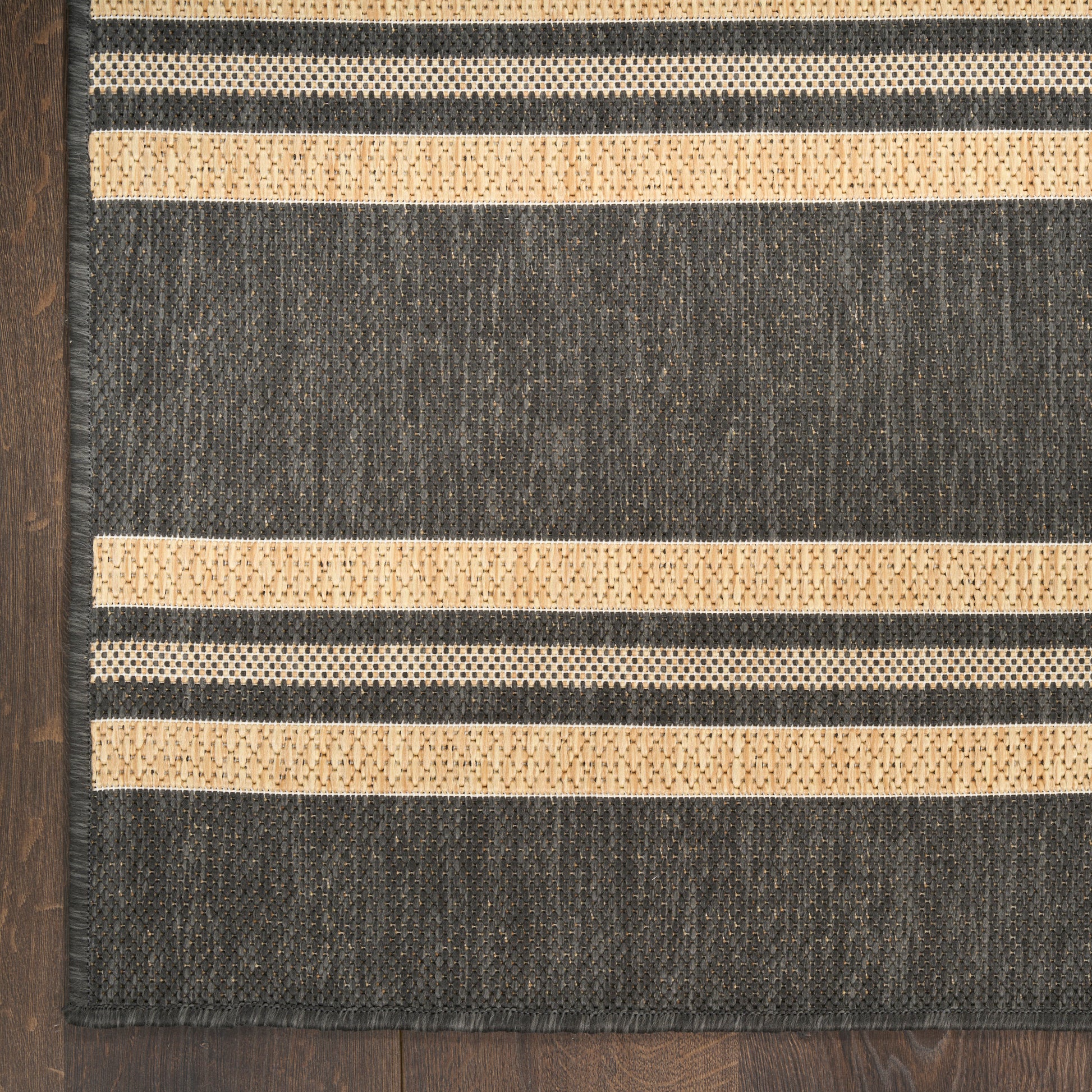 Charcoal gray woven rug with beige dotted stripes; rectangular, modern coastal style for living spaces.