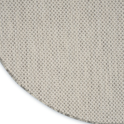 Round beige textured rug with tiny diamond weave; soft neutral fabric, living room or dining decor.