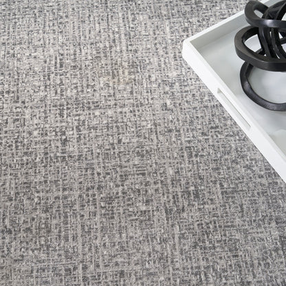 Gray textured area rug with a white rectangular tray holding black circular gas burner rings.
