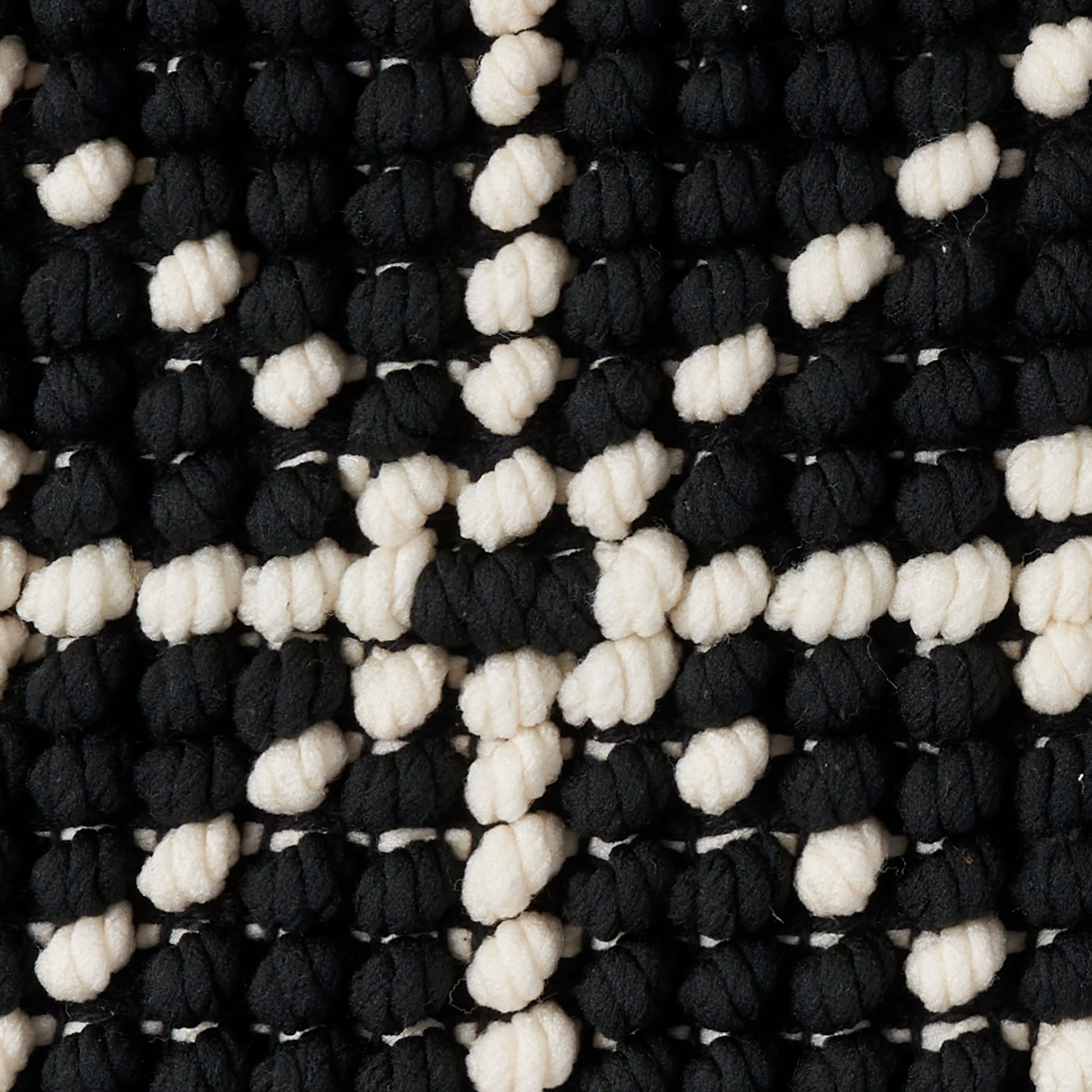 Chunky black and white boucle knit rug with knobby loops in a checker pattern, 20" x 20