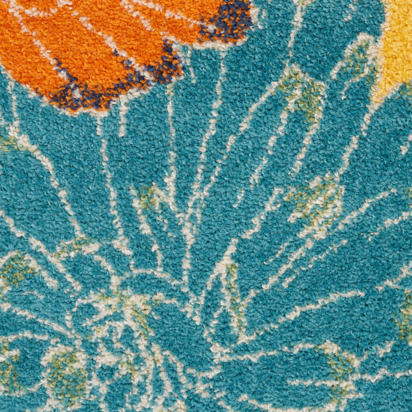 Blue shag rug with white sunburst radiating lines and orange and yellow accents, plush textured pile.