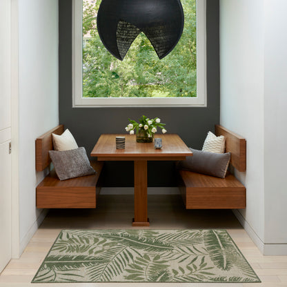 Wood dining nook with L-shaped benches, square table, gray cushions, leafy rug, dark wall and black woven pendant light.