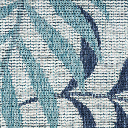 Close-up of teal and navy woven fabric with geometric leaf pattern and textured weave.