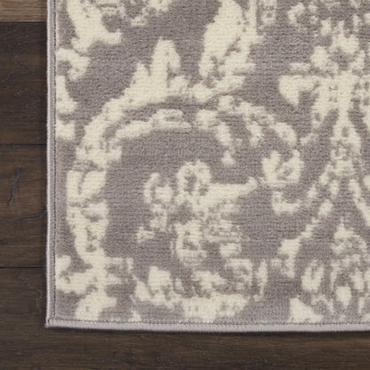 Gray & ivory damask rug with floral pattern, flatwoven look, light gray binding edge on hardwood floor.