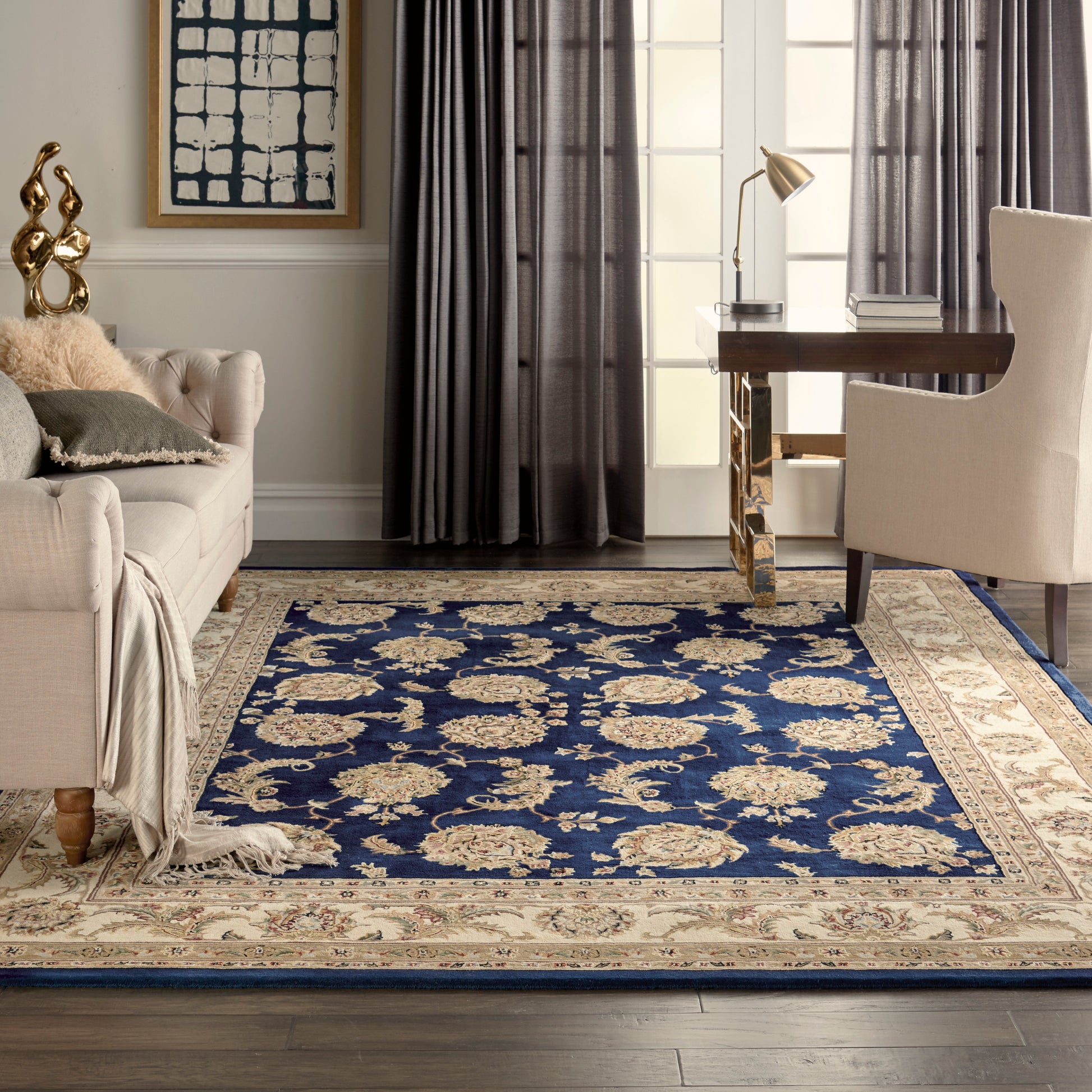Navy blue Persian-style area rug with ivory floral motifs and beige border in a modern living room.