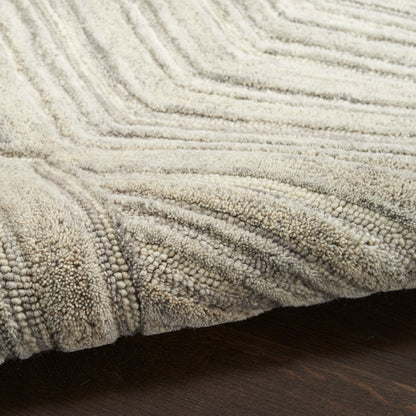 Beige plush shag rug with thick looped pile and geometric ridges on dark wood floor, ideal for living rooms.