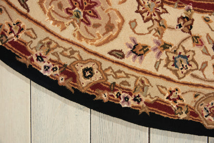 Ornate oriental rug with cream, red and beige floral pattern and a black border on a light wooden floor.