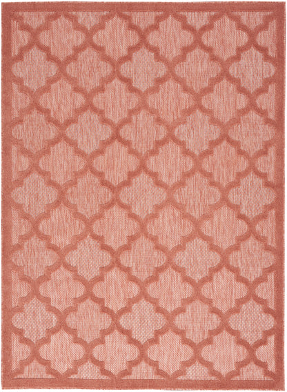 Rectangular coral rug featuring a textured trellis lattice pattern in matching shade, woven surface.