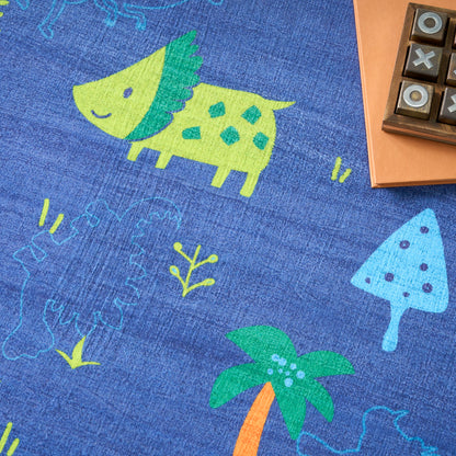 Blue kids' play rug with lime-green dinosaur, teal mushrooms, and palm tree; neon doodle print on soft woven fabric.
