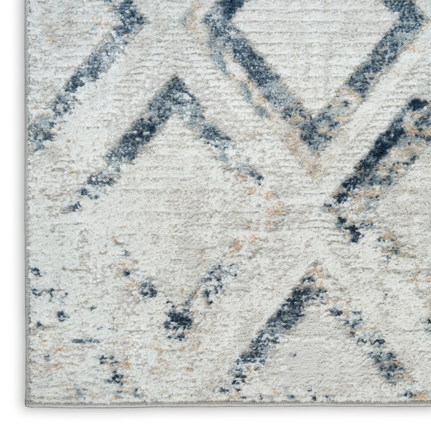 Cream shag rug with blue diamond geometric pattern; soft, high-pile texture.