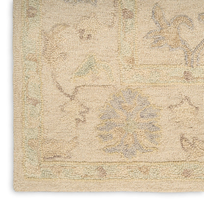 Beige vintage-style oriental rug with pale blue, sage and peach floral motifs; loop pile and bordered edges.