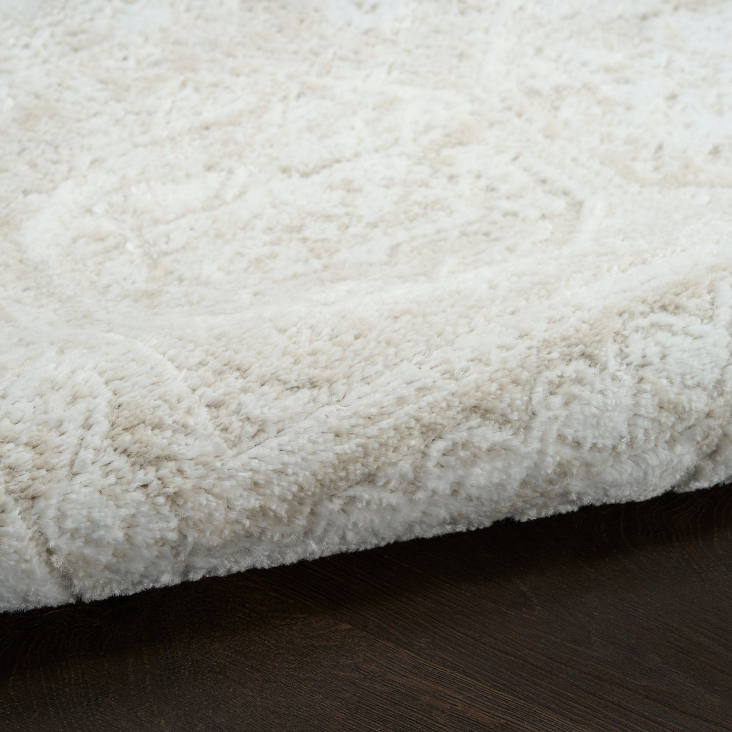 White fluffy shag rug on dark wooden floor; plush, cozy home decor.