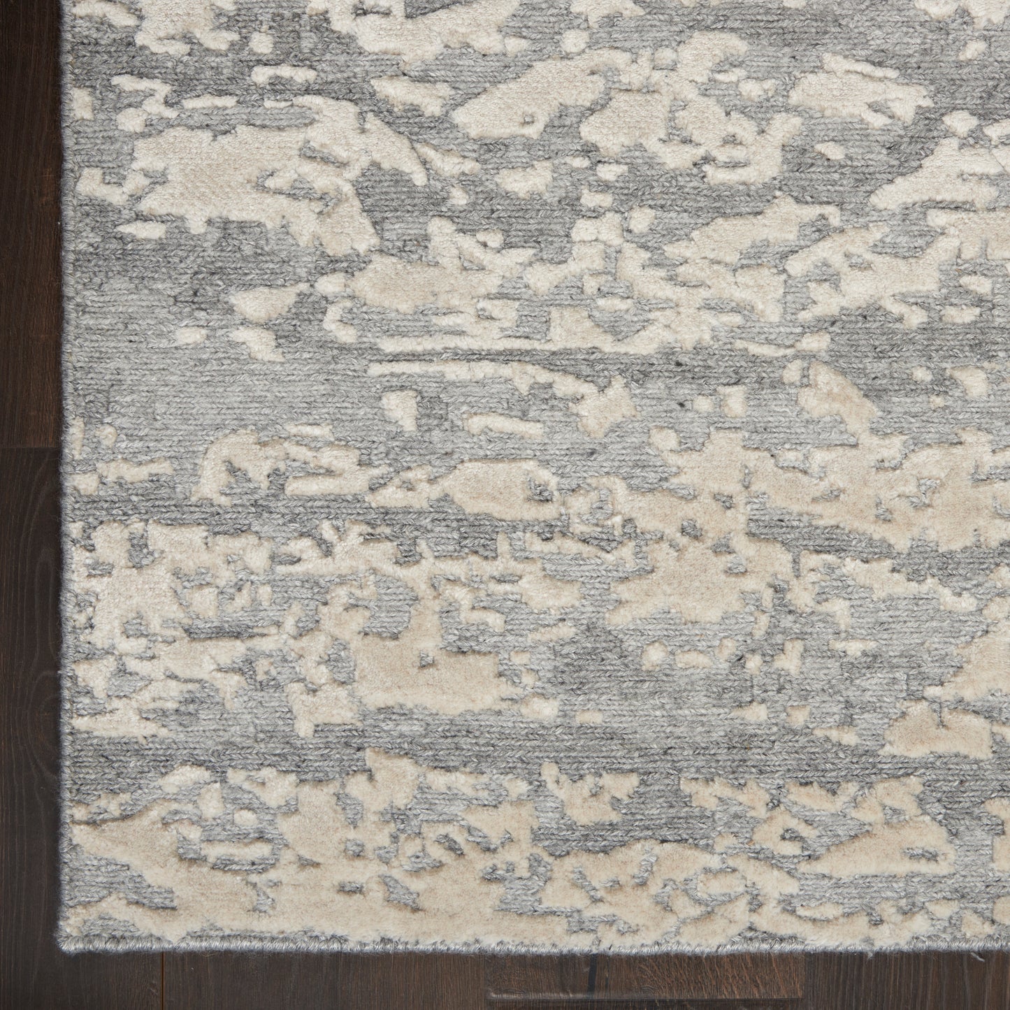 Rectangular gray & cream abstract-pattern area rug with plush texture on dark hardwood floor.